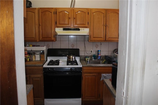 kitchen with backsplash, sink, and white gas range oven