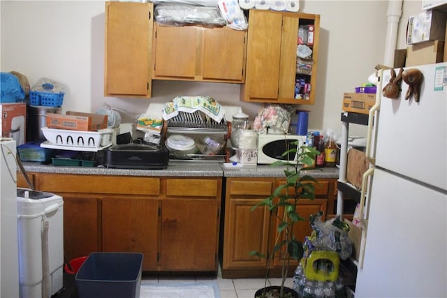 kitchen featuring light tile patterned flooring and white appliances