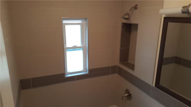 bathroom featuring tiled shower / bath combo and a healthy amount of sunlight