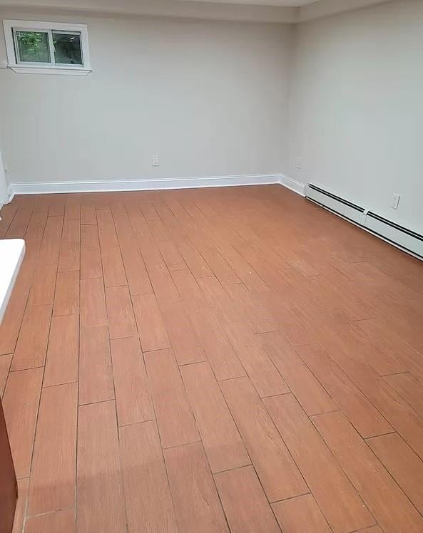 spare room featuring light hardwood / wood-style floors and a baseboard heating unit