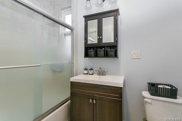 full bathroom featuring shower / bath combination with glass door, vanity, and toilet