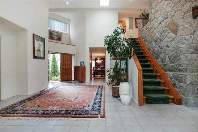 foyer featuring light tile patterned floors and a high ceiling