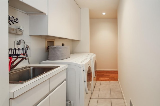 laundry room with cabinets, independent washer and dryer, sink, and light tile patterned floors