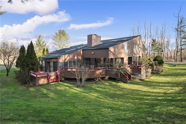 back of property featuring a sunroom and a lawn