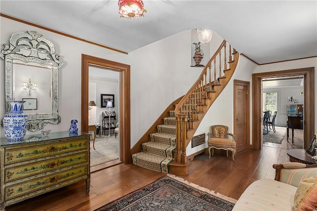 staircase with hardwood / wood-style flooring and ornamental molding