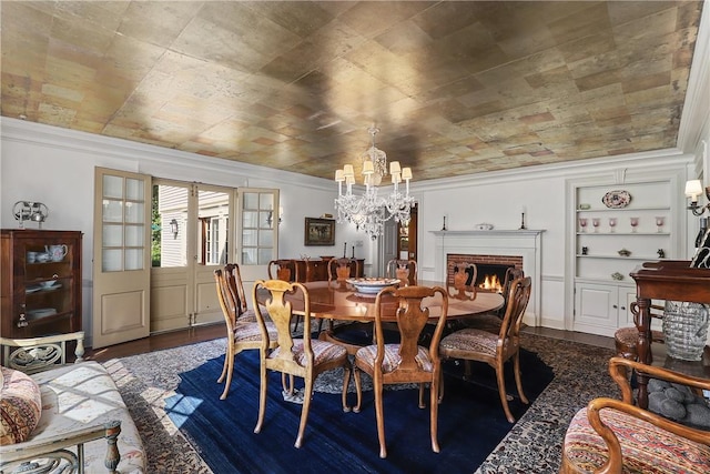 dining room with built in features, crown molding, and dark wood-type flooring