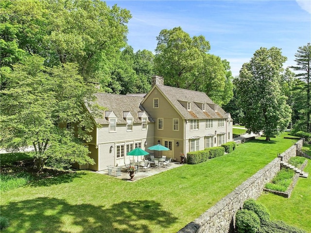 rear view of property featuring a yard and a patio area