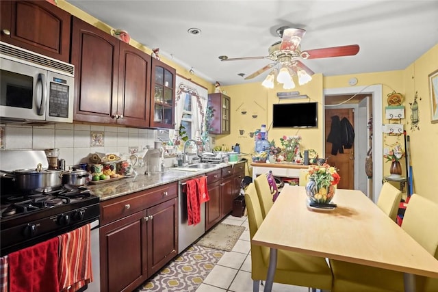 kitchen with appliances with stainless steel finishes, tasteful backsplash, ceiling fan, sink, and light tile patterned floors