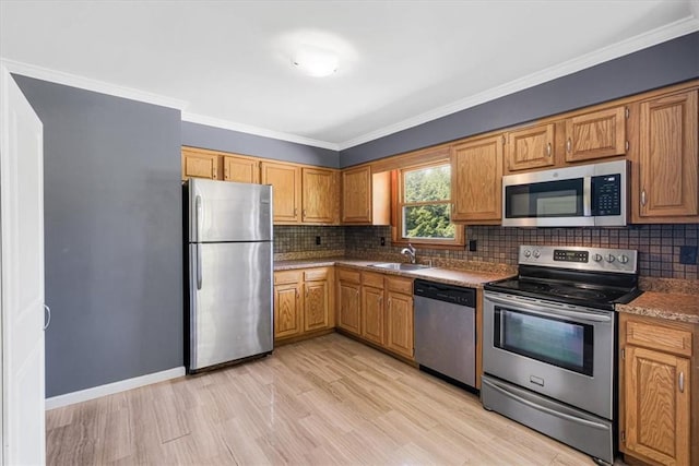 7 Joan Ln, Wappingers Falls, NY 12590 - kitchen featuring stainless steel appliances, backsplash, light wood-style flooring, crown molding, and a sink