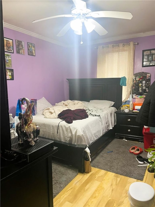 bedroom featuring ceiling fan, wood-type flooring, and ornamental molding