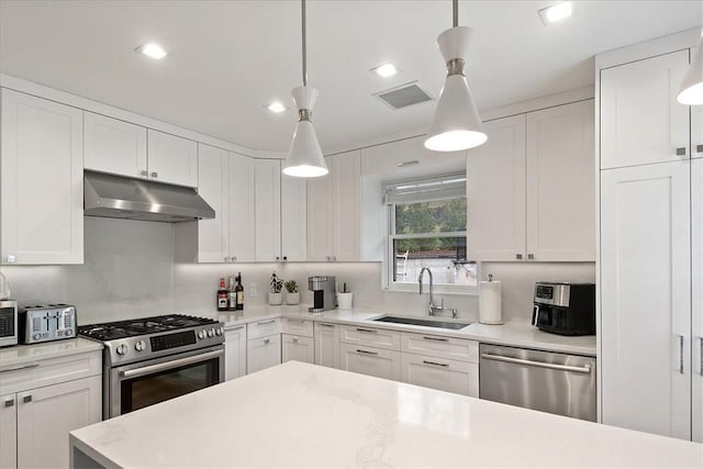 kitchen featuring white cabinetry, sink, pendant lighting, and appliances with stainless steel finishes