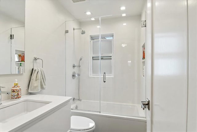 full bathroom with vanity, toilet, and bath / shower combo with glass door