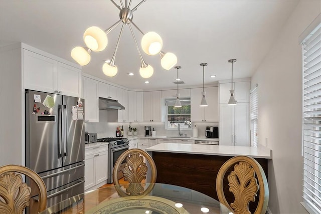 kitchen with decorative light fixtures, stainless steel appliances, white cabinetry, and sink