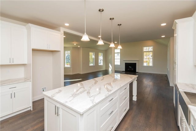 kitchen featuring white cabinetry, hanging light fixtures, a kitchen island, and dark wood-type flooring