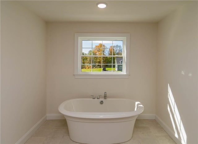 bathroom with tile patterned flooring and a bath