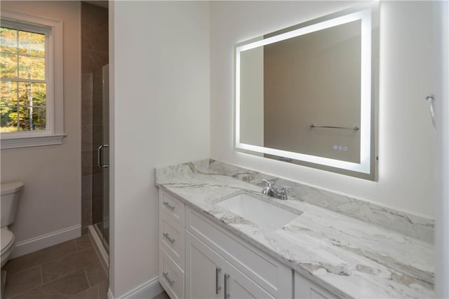 bathroom featuring tile patterned flooring, vanity, toilet, and a shower with shower door