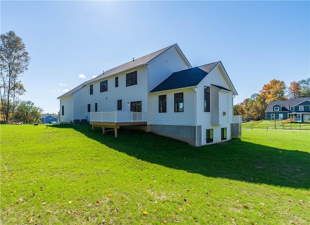 rear view of property with a wooden deck and a yard