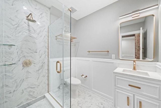 bathroom with a shower with door, vanity, and toilet