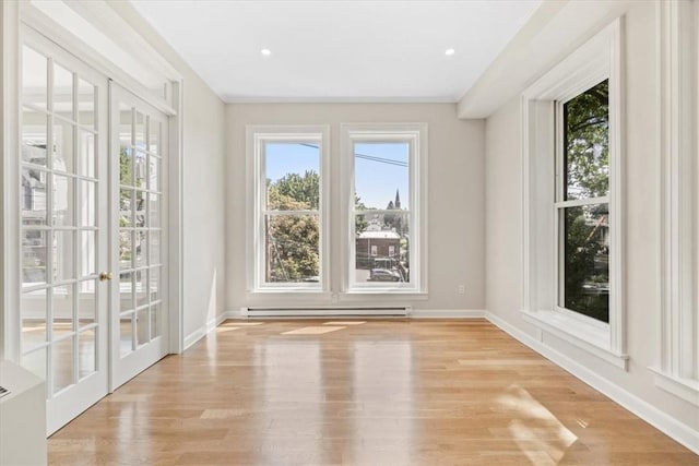 unfurnished sunroom featuring a baseboard radiator and french doors