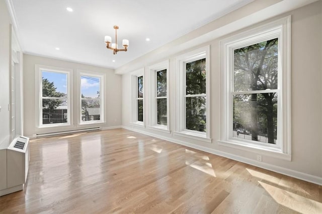 unfurnished sunroom with an inviting chandelier, a healthy amount of sunlight, and baseboard heating