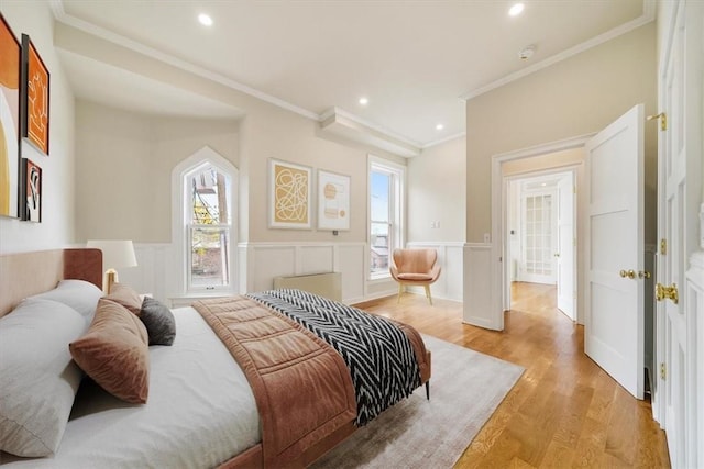 bedroom with multiple windows, ornamental molding, and light hardwood / wood-style flooring