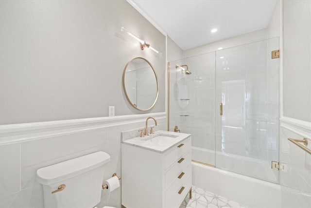 full bathroom with vanity, bath / shower combo with glass door, and toilet