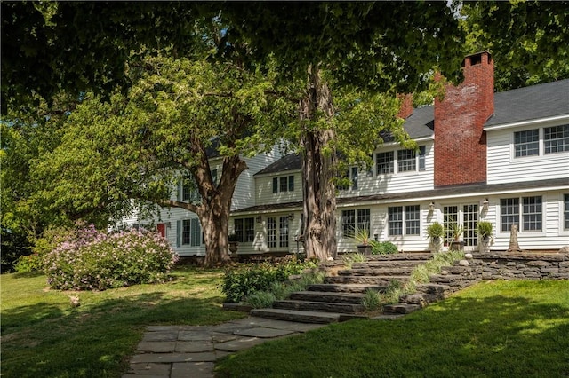 rear view of house featuring a yard