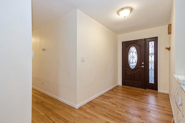 foyer entrance with light wood-style flooring and baseboards