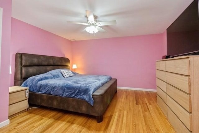 bedroom featuring a ceiling fan, light wood-style flooring, and baseboards