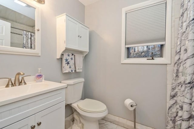 bathroom featuring marble finish floor, a shower with shower curtain, toilet, vanity, and baseboards