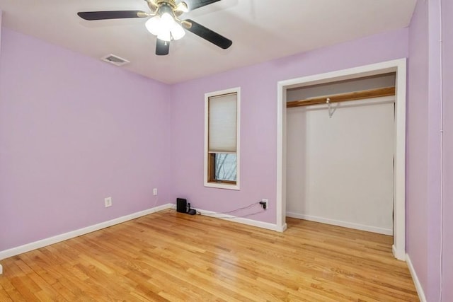 unfurnished bedroom featuring a closet, visible vents, light wood-style flooring, ceiling fan, and baseboards