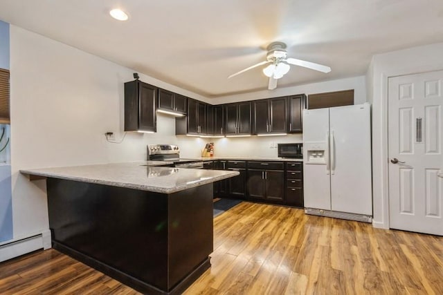 kitchen with electric stove, white refrigerator with ice dispenser, baseboard heating, black microwave, and a peninsula