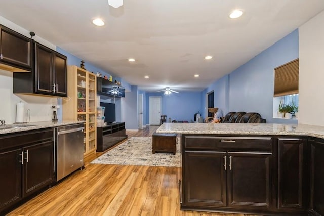 kitchen featuring a sink, a ceiling fan, open floor plan, stainless steel dishwasher, and light wood-type flooring