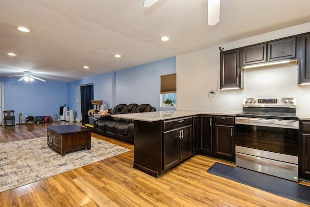 kitchen featuring electric range, ceiling fan, open floor plan, a peninsula, and light wood-style floors