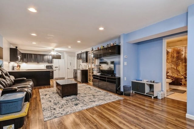 living area featuring a ceiling fan, wood finished floors, and recessed lighting