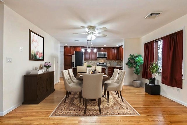 dining area with a ceiling fan, light wood-style flooring, visible vents, and baseboards