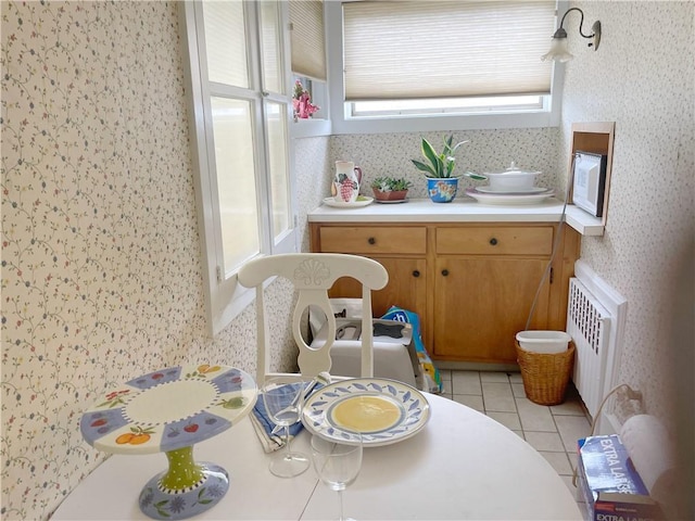 tiled dining space featuring radiator heating unit