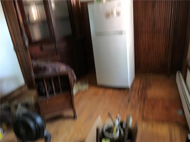 bedroom featuring hardwood / wood-style floors, a closet, and a baseboard heating unit