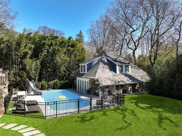 view of swimming pool with a patio area, a yard, and a water slide