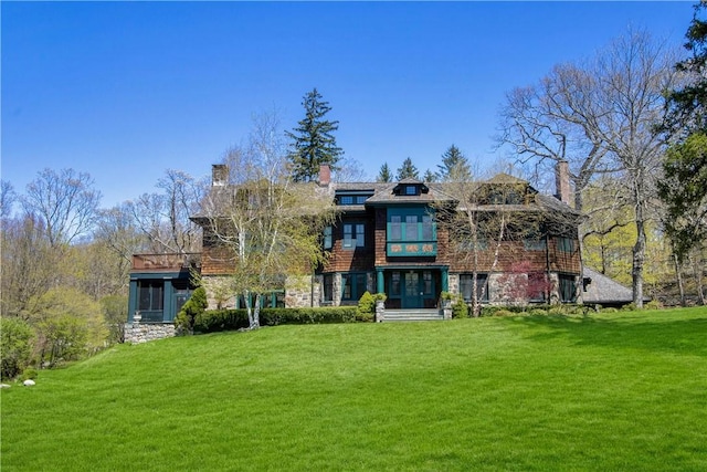 rear view of house with a lawn and a sunroom