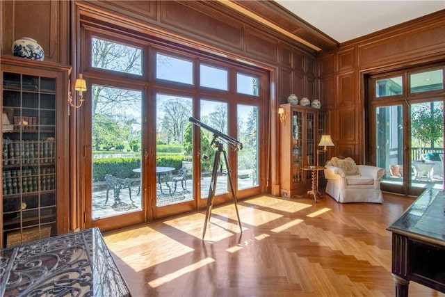 doorway to outside with a wealth of natural light and wood walls