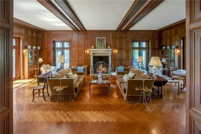 living room featuring beam ceiling, light parquet flooring, crown molding, and wooden walls