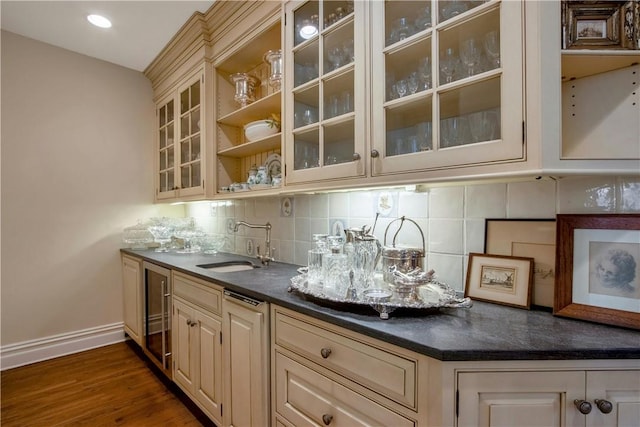 bar with cream cabinets, dark hardwood / wood-style floors, sink, and tasteful backsplash