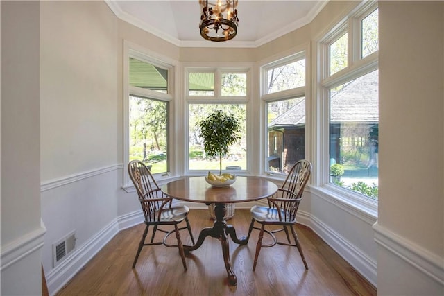 sunroom featuring plenty of natural light and a notable chandelier