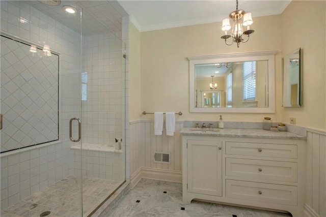 bathroom with vanity, ornamental molding, a shower with door, and an inviting chandelier