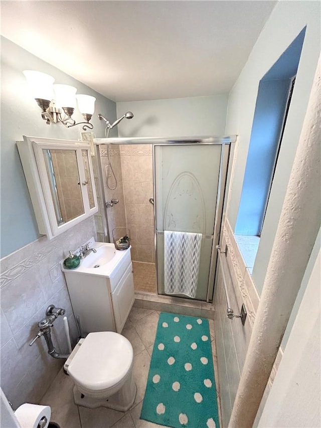 bathroom with tile patterned floors, an enclosed shower, vanity, tile walls, and a notable chandelier