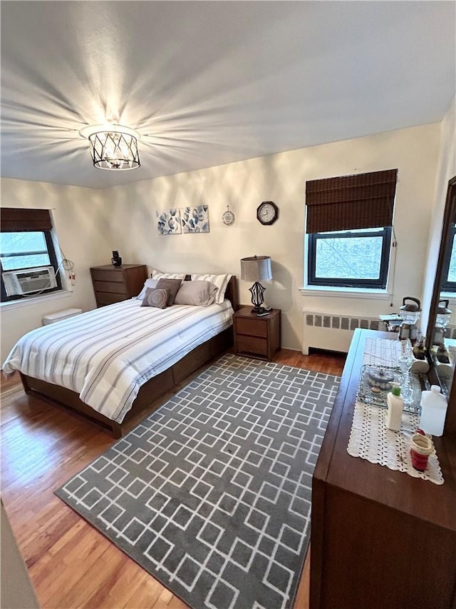 30 Fleetwood Ave Unit 4F, Mount Vernon, NY 10552 - bedroom featuring radiator heating unit, wood finished floors, multiple windows, and cooling unit