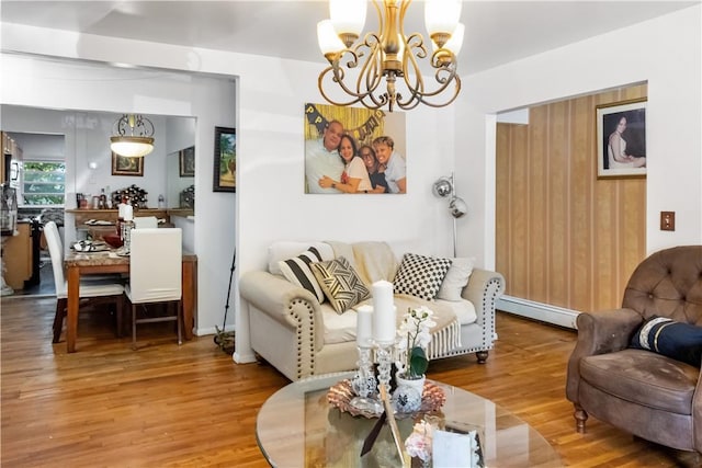 living room with a chandelier, a baseboard heating unit, and hardwood / wood-style flooring