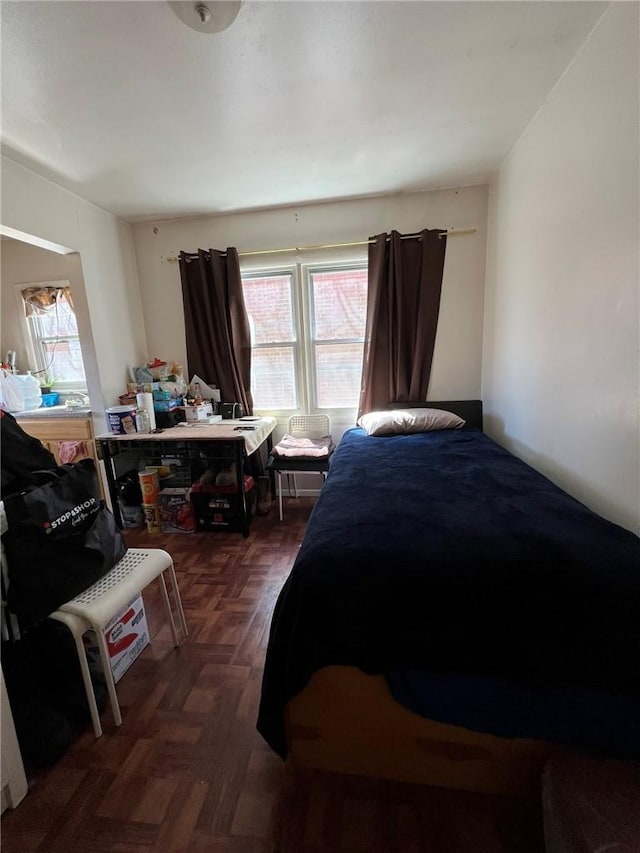 bedroom featuring dark parquet flooring