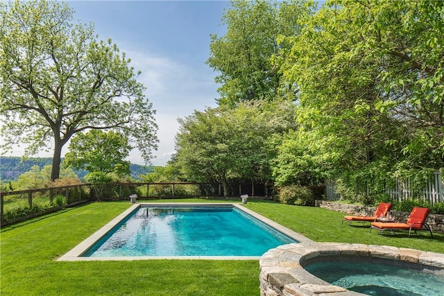 view of swimming pool featuring a lawn and an in ground hot tub